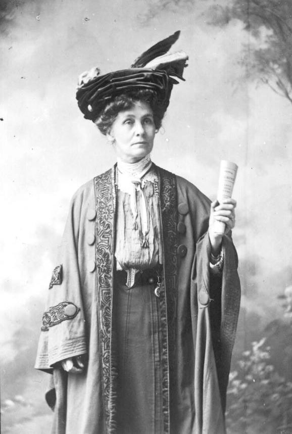 Doc-COPY-1 526 3-Photograph-of-Mrs-Pankhurst-leader-of-Votes-for-Women-movement-London-three-quarter-length-hand-upraised-holding-paper-wearing-hat-and-cloak..jpg